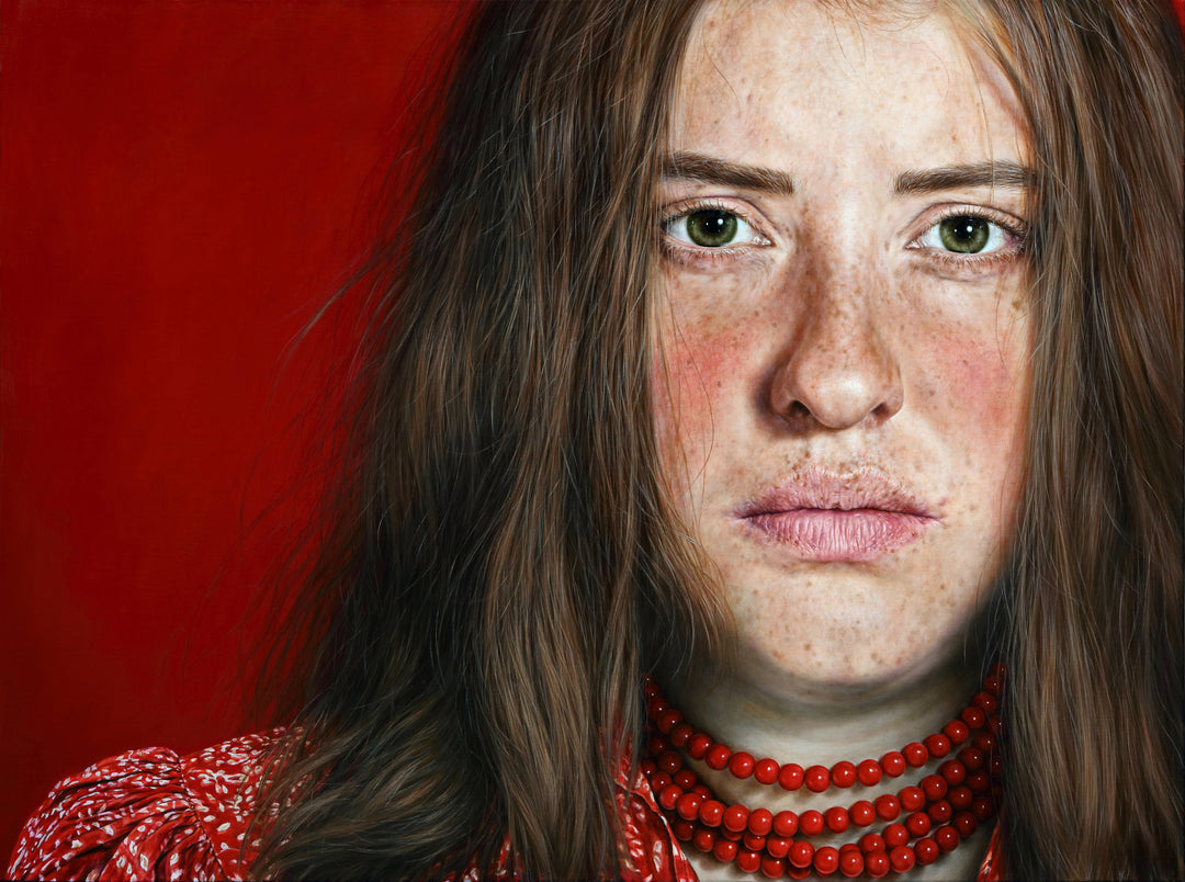 Arina Gordienko hyperrealist oil painting Life in Crimson Flame, depicting a young woman with freckled skin, green eyes, and long brown hair, wearing a vivid red blouse and layered red bead necklace against a deep red background. The portrait conveys resilience, emotional depth, and the struggle between past sorrow and future hope.