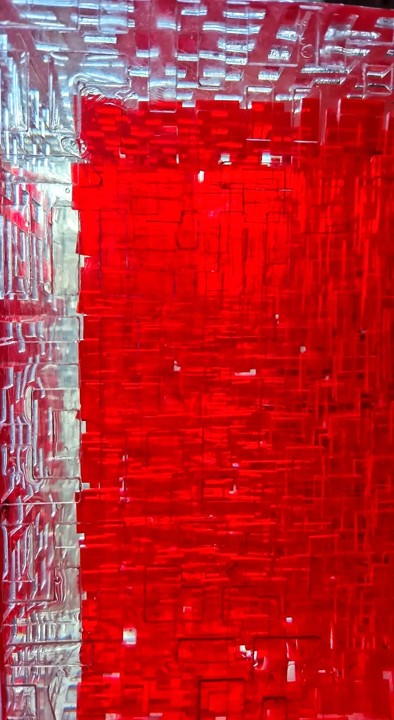A one-off sculptural cube by Richard Slee, constructed from neon red acrylic and clear resin. The work features a dense, layered grid pattern that plays with light, depth, and shadow—creating a luminous, architectural object with a strong geometric presence. The cube glows from within, drawing the viewer into its intricate interior.