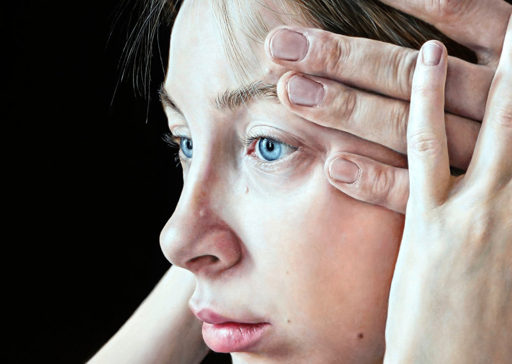Arina Gordienko hyperrealist oil painting When Fate Was Tracing Us Behind, depicting a young woman with piercing blue eyes in profile, her face framed by her own hand and a man’s larger hand pressing against her head. She wears a muted grey-blue shirt, set against a stark black background. The composition conveys themes of inevitability, mortality, fate, and human vulnerability, inspired by Arseny Tarkovsky’s poetry.