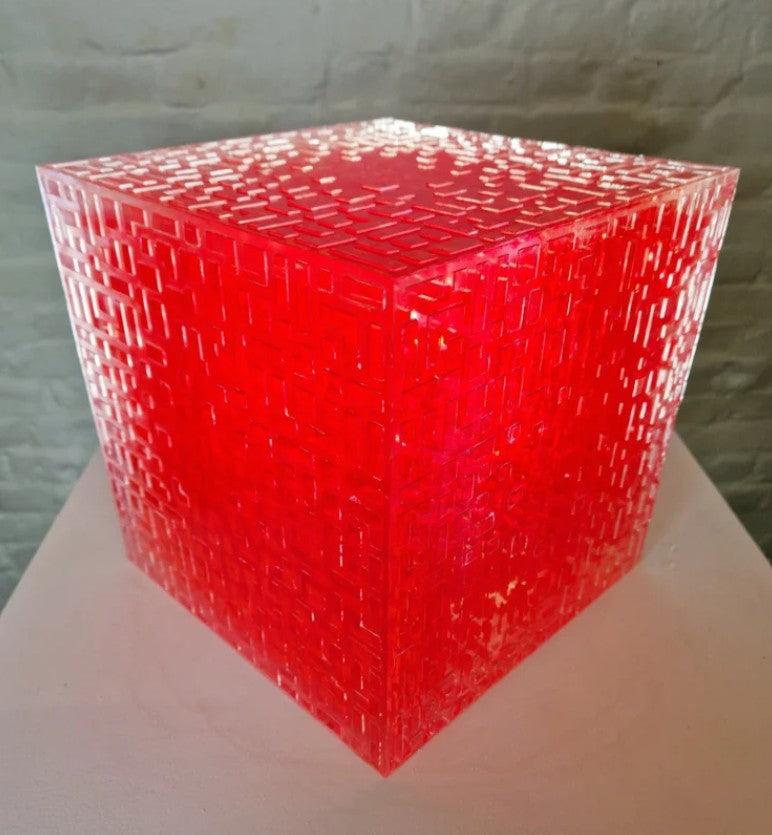 A one-off sculptural cube by Richard Slee, constructed from neon red acrylic and clear resin. The work features a dense, layered grid pattern that plays with light, depth, and shadow—creating a luminous, architectural object with a strong geometric presence. The cube glows from within, drawing the viewer into its intricate interior.