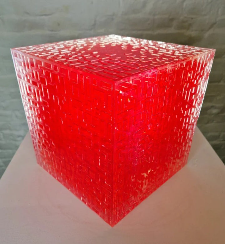 A one-off sculptural cube by Richard Slee, constructed from neon red acrylic and clear resin. The work features a dense, layered grid pattern that plays with light, depth, and shadow—creating a luminous, architectural object with a strong geometric presence. The cube glows from within, drawing the viewer into its intricate interior.