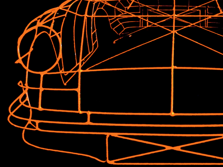 Handcrafted Porsche 911 2.7 RS wire sculpture by Chris Twitchell, finished in vivid Tangerine orange with black Carrera script. This detailed artwork captures the iconic pre-impact bumper 911 form — from its classic round headlights to the signature ducktail spoiler — reimagined as a precision-engineered wireframe sculpture that celebrates Porsche’s timeless design and performance heritage.