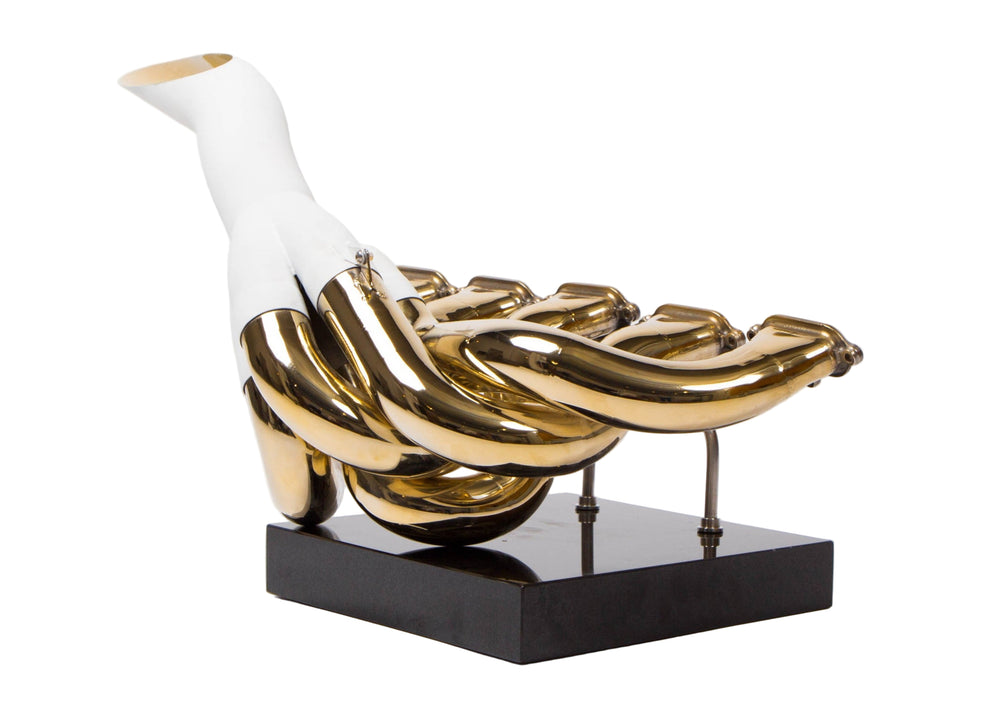 One-of-one sculptural artwork by Mike O’Connor created from the complete race-used exhaust system of the 2001 Jordan EJ11 Formula One car. The piece is fully plated in 24-karat gold, showcasing hand-polished Inconel pipes mounted on a sleek black plinth. This gleaming sculpture celebrates the V10 era of Formula One and the engineering innovation of Eddie Jordan’s team