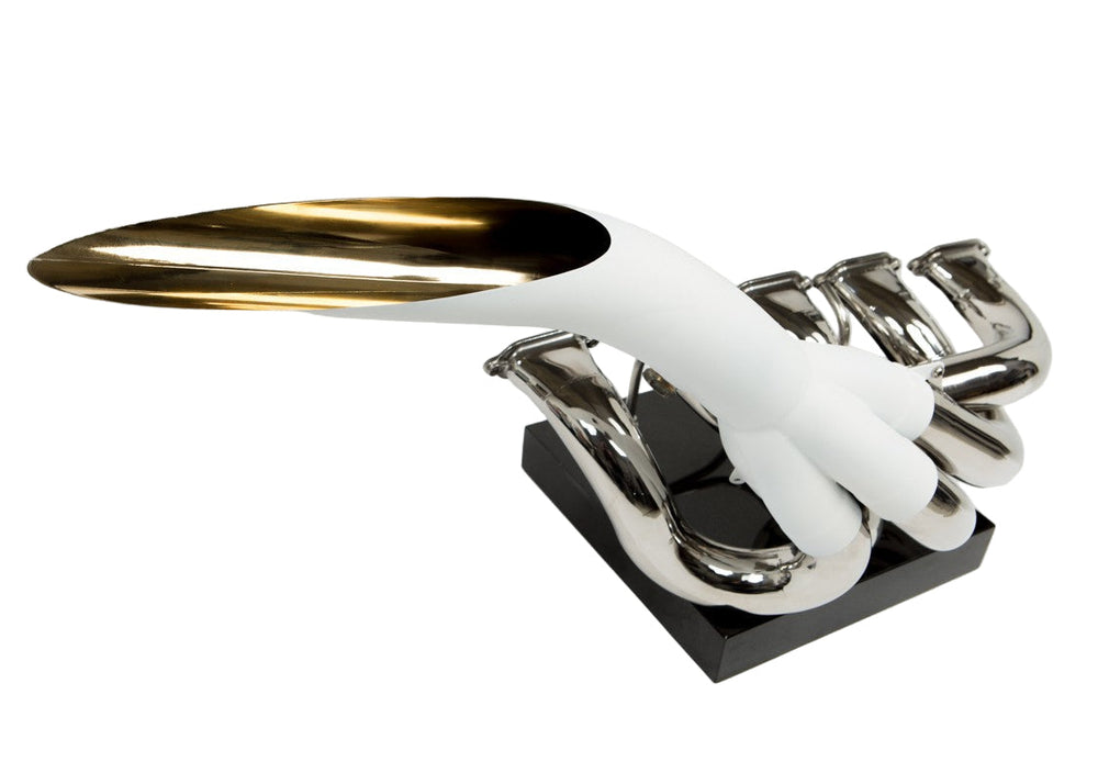 Highly polished sculptural artwork by Mike O’Connor crafted from the authentic race-used exhaust system of Michael Schumacher’s 1995 Benetton B195 Formula One car. The piece features flowing Inconel and stainless-steel pipes with mirror-finished chrome surfaces and 24-karat gold interior detailing, mounted on a sleek stand. A striking one-of-one collector’s piece 