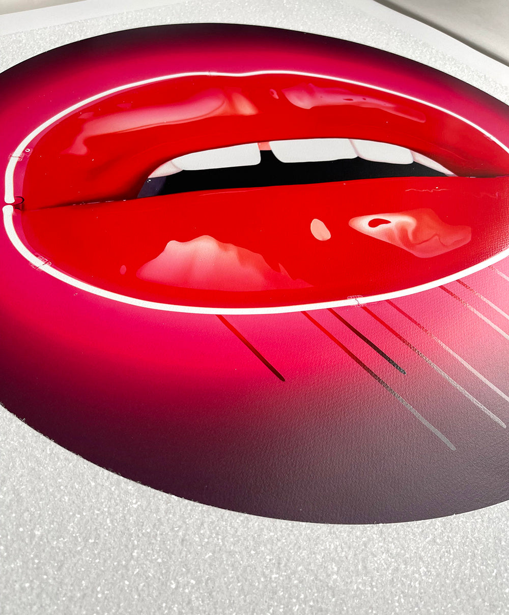 Glossy red lips outlined in neon pink with dripping paint on a circular black and pink background.
