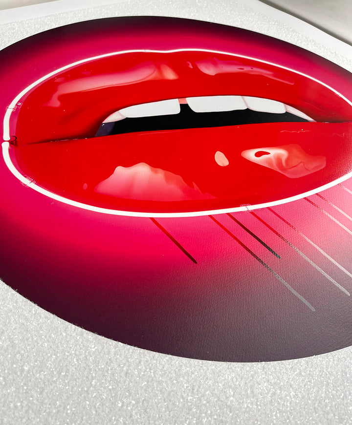 Glossy red lips outlined in neon pink with dripping paint on a circular black and pink background.
