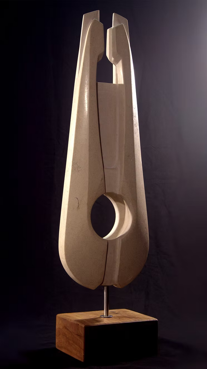 Stone sculpture featuring two tall, curved spires carved from Purbeck Thornback stone, set on a polished black granite base, connected by a narrow central opening with stainless steel elements, displayed against a dark background.