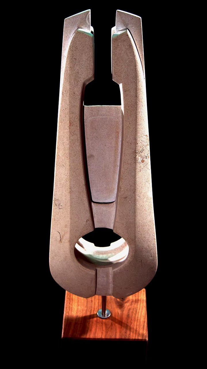 Stone sculpture featuring two tall, curved spires carved from Purbeck Thornback stone, set on a polished black granite base, connected by a narrow central opening with stainless steel elements, displayed against a dark background.