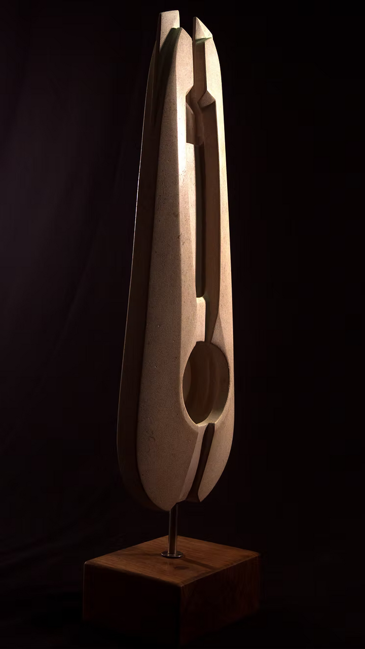 Stone sculpture featuring two tall, curved spires carved from Purbeck Thornback stone, set on a polished black granite base, connected by a narrow central opening with stainless steel elements, displayed against a dark background.