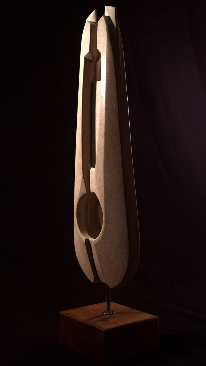 Stone sculpture featuring two tall, curved spires carved from Purbeck Thornback stone, set on a polished black granite base, connected by a narrow central opening with stainless steel elements, displayed against a dark background.