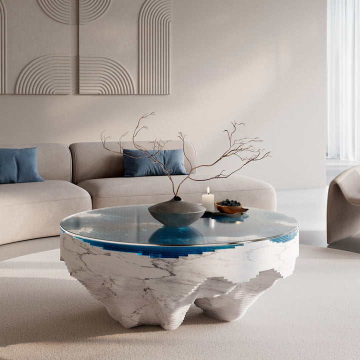 Duffy London Abyss Marble Horizon coffee table in white Carrara marble with layered blue glass, creating a sculptural ocean-depth illusion within a circular form.