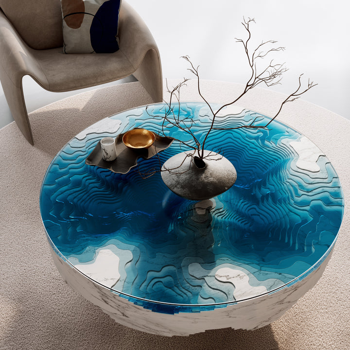 Duffy London Abyss Marble Horizon coffee table in white Carrara marble with layered blue glass, creating a sculptural ocean-depth illusion within a circular form.