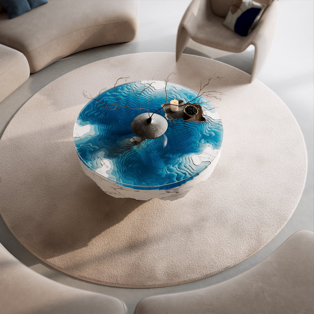 Duffy London Abyss Marble Horizon coffee table in white Carrara marble with layered blue glass, creating a sculptural ocean-depth illusion within a circular form.