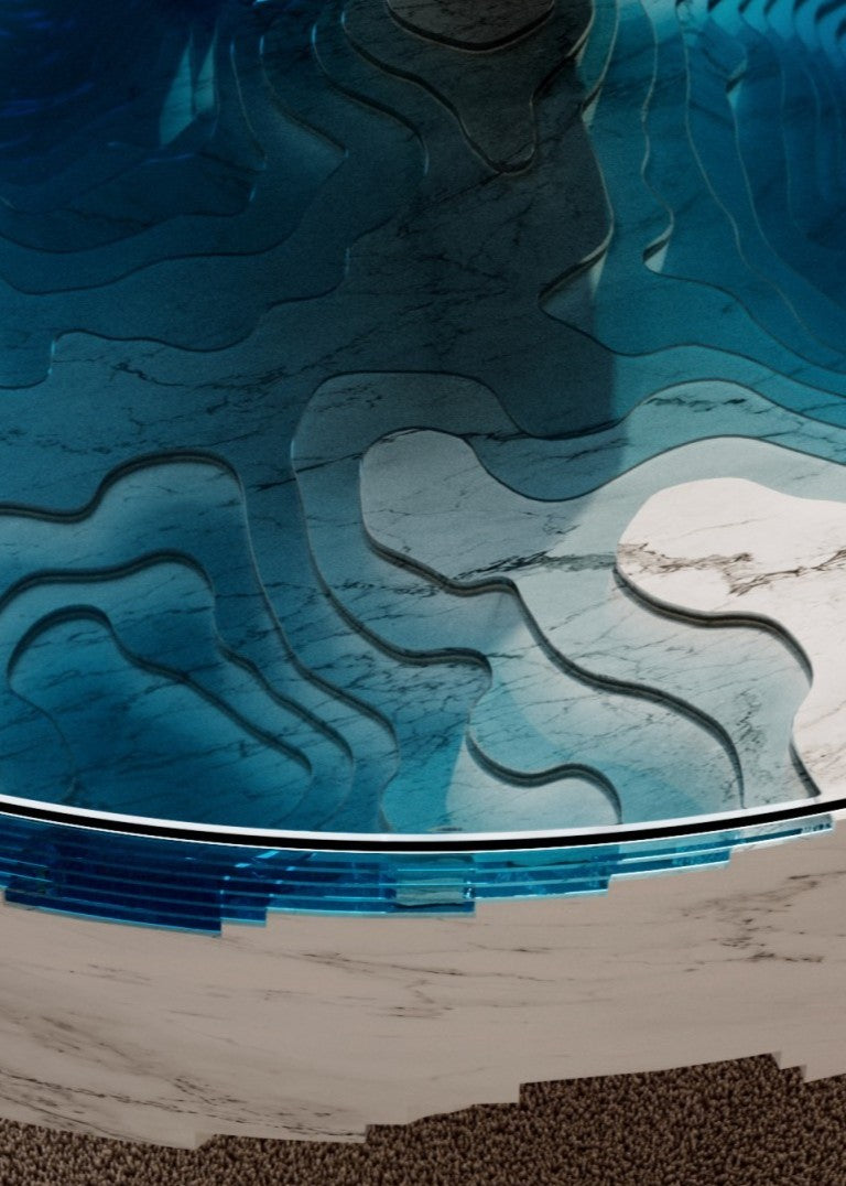 Duffy London Abyss Marble Horizon coffee table in white Carrara marble with layered blue glass, creating a sculptural ocean-depth illusion within a circular form.