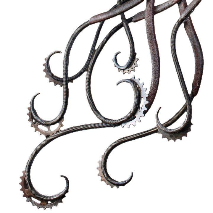 Winged steampunk Phoenix sculpture crafted from reclaimed metal with mechanical detailing and flowing tentacle-like elements.