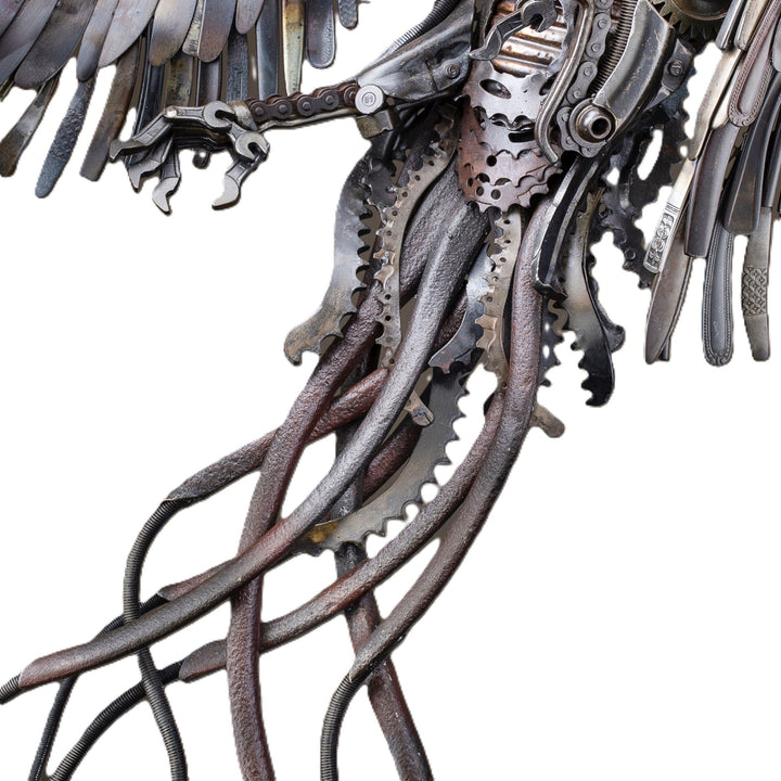 Winged steampunk Phoenix sculpture crafted from reclaimed metal with mechanical detailing and flowing tentacle-like elements.