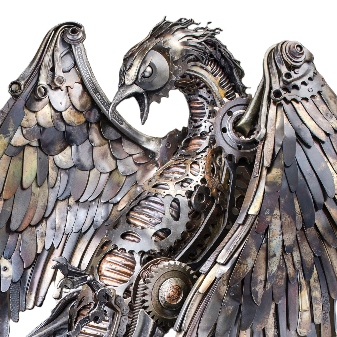 Winged steampunk Phoenix sculpture crafted from reclaimed metal with mechanical detailing and flowing tentacle-like elements.