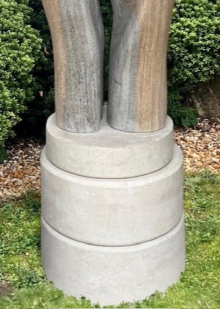 Contemporary stone sculpture titled Almost Touching, carved from Ancaster Weatherbed and set on a Portland stone base. Two elegant vertical forms rise in soft curves, nearly meeting at the centre, symbolising connection and balance within natural harmony.