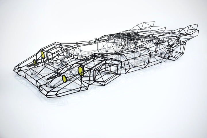 Large skeletal sculpture of a Porsche 917 race car, half-size, created from black carbon fibre and aluminium rods with yellow headlight details — an intricate polygonal framework inspired by the 1971 Le Mans–winning Porsche 917K.