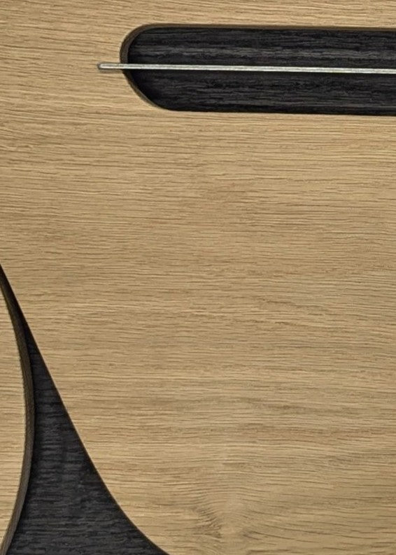 Jonny Ambrose minimalist oak wall sculpture featuring the side profile of an Aston Martin DB5 with carved wheel arch and signature side vent, accented with aluminium detail on a white Corian backdrop.