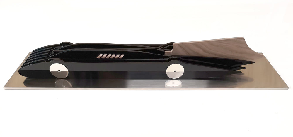 Limited-edition Bluebird V 1935 sculpture by Jonny Ambrose — layered black polished acrylic body with walnut tail-fin and polished nickel-plated aluminium details on a sleek white acrylic or brushed aluminium plinth, celebrating Malcolm Campbell’s 1935 land speed record at Bonneville Salt Flats.