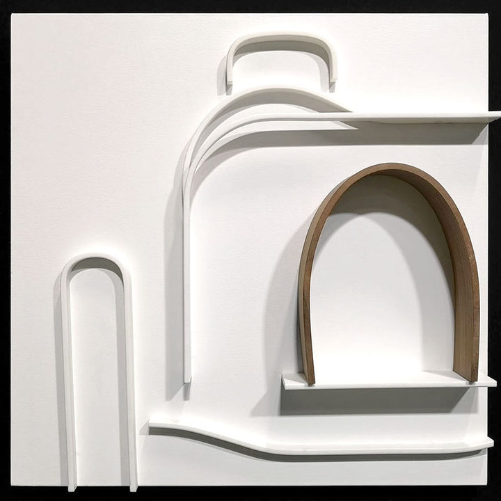 Minimalist wall sculpture of the 1930s Bugatti Type 35B Grand Prix car by Jonny Ambrose — crisp white Corian relief with warm walnut arch detail, framed in deep black for bold gallery impact.