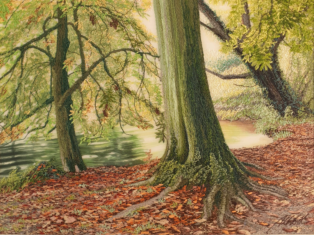 Embroidered woodland scene with moss-covered tree trunks, autumn leaves on the forest floor, and a calm river reflecting soft light.