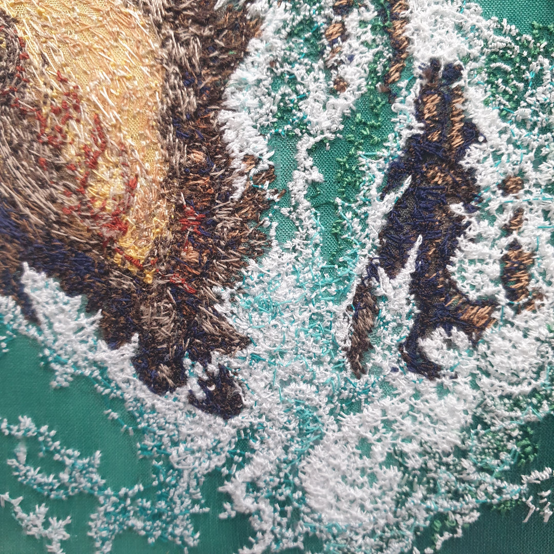 Textile artwork depicting rocky outcrops surrounded by swirling green-blue sea, created with freehand machine embroidery on painted silk.