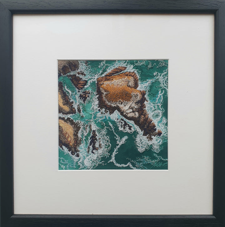 Textile artwork depicting rocky outcrops surrounded by swirling green-blue sea, created with freehand machine embroidery on painted silk.