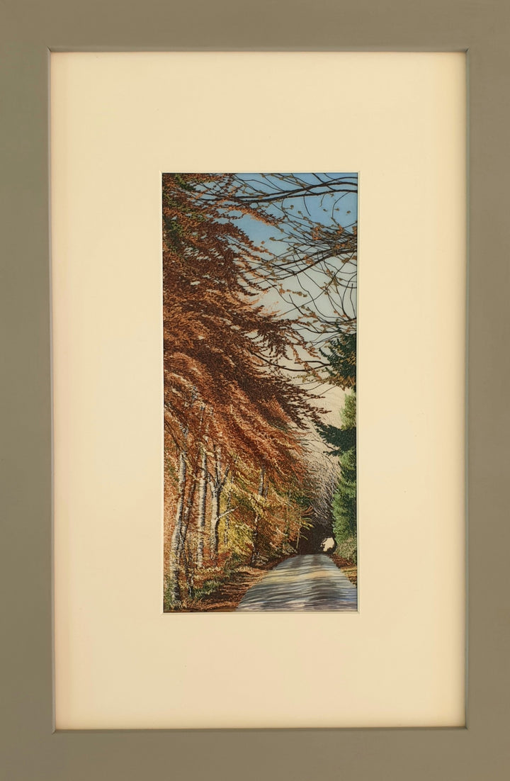 Tall embroidered artwork of a quiet road lined with autumnal trees in golden brown and orange thread, under a pale blue sky.