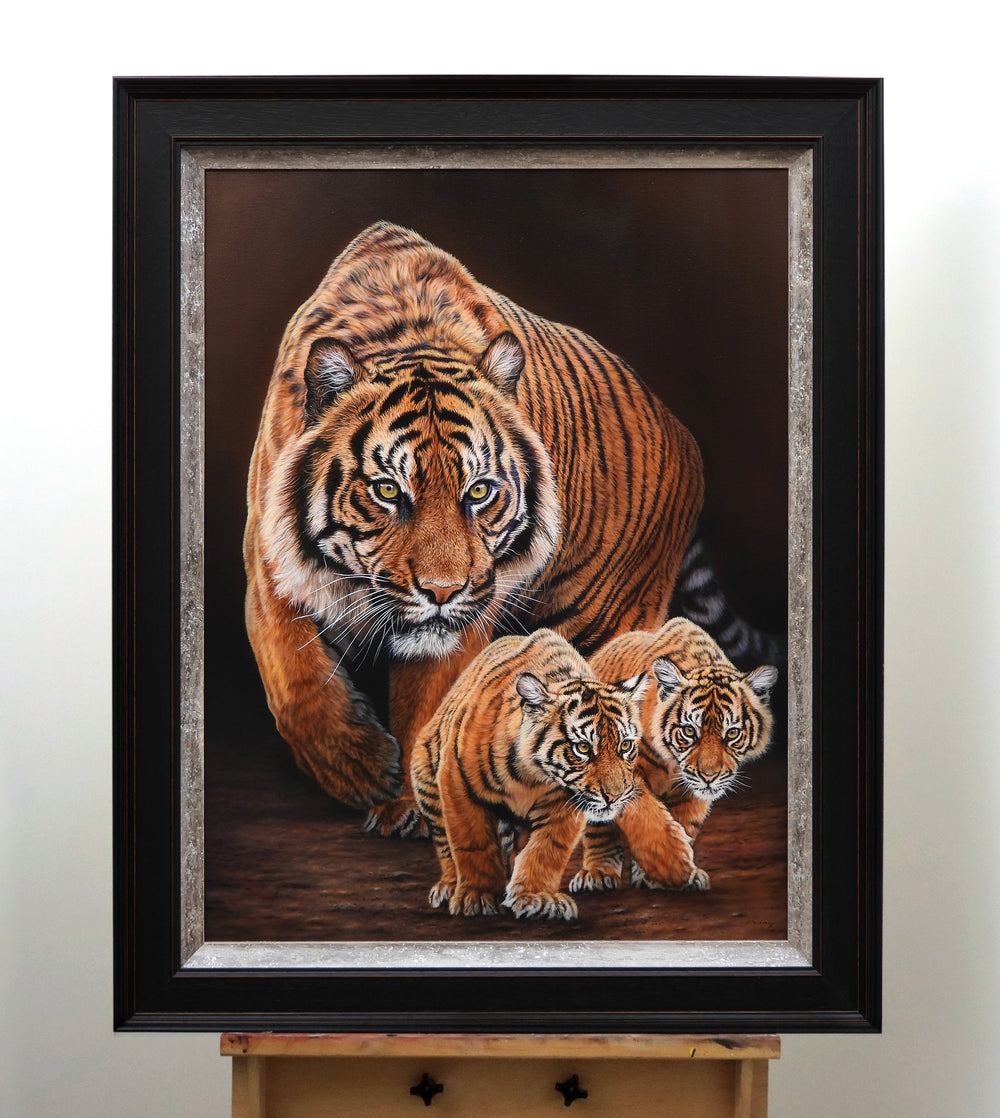 Realistic painting of a tiger with two cubs walking cautiously forward.