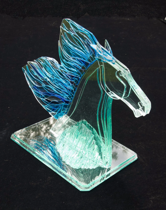 Bonded glass sculpture of a horse titled Winner, featuring a stylised mane in layered blue and turquoise glass, set on a rectangular base, suitable for indoor or outdoor display.