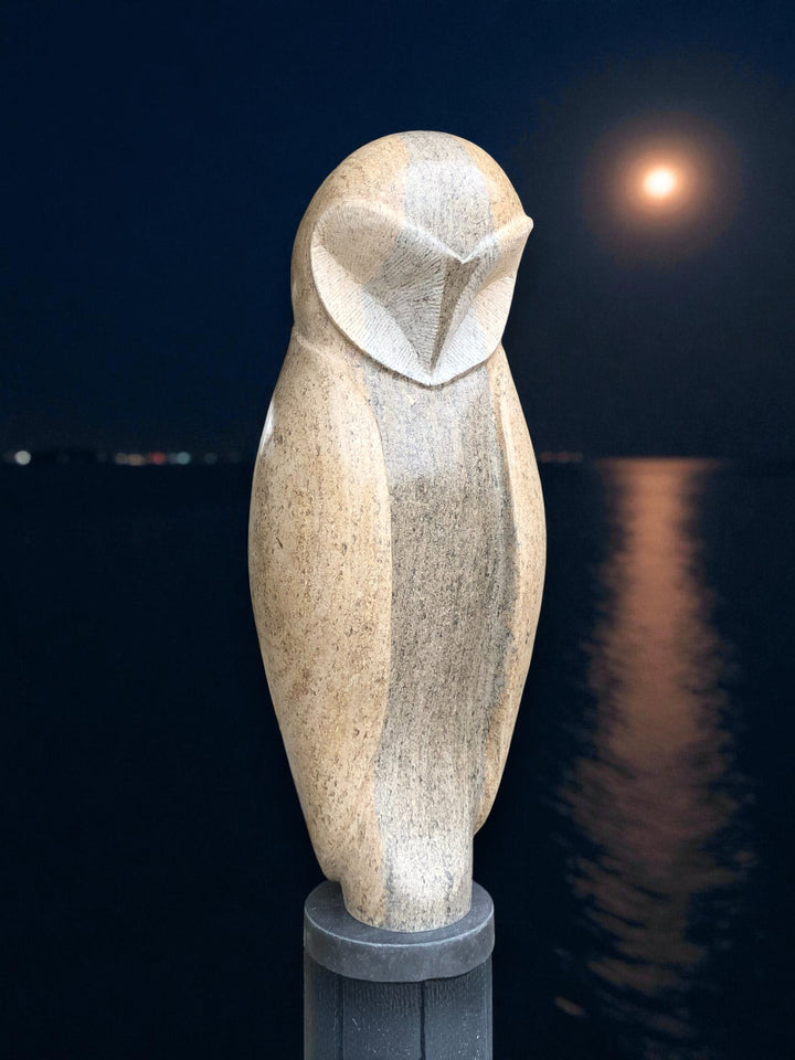 Hand-carved stone barn owl sculpture in Ancaster Weatherbed limestone, tall and elegant on a plinth with a smooth stylised form.