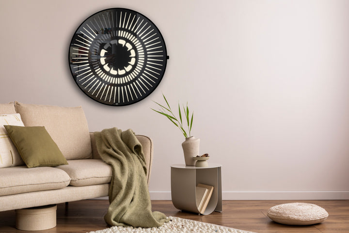 “Tempus Obsidian” by Ben Rousseau – a limited-edition illuminated wall timepiece crafted from grey mirrored glass and brass-tinted aluminium with LEDs. Inspired by obsidian, it radiates calm through subtle light and refined design.

