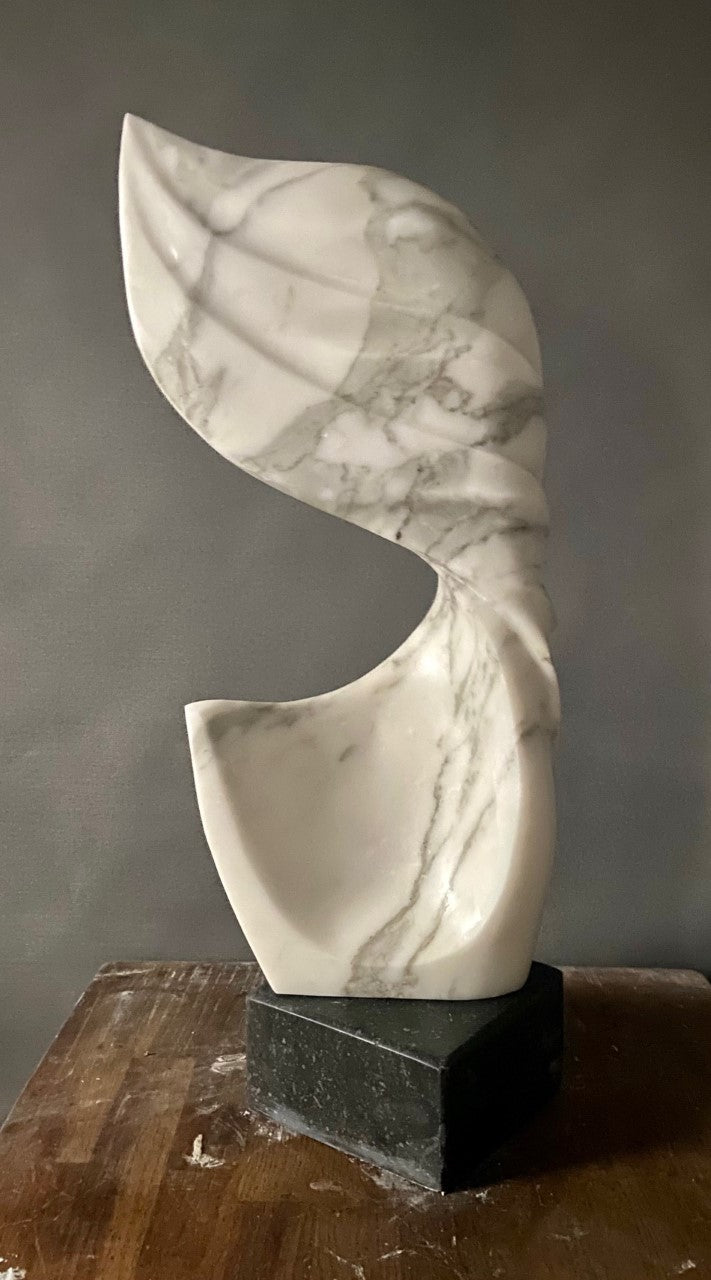 Billow 2 by Brendan Cullen, hand-carved from Carrara marble, featuring flowing organic curves with grey veining, a sculptural form evoking wind or water in motion, set on a dark stone base.
