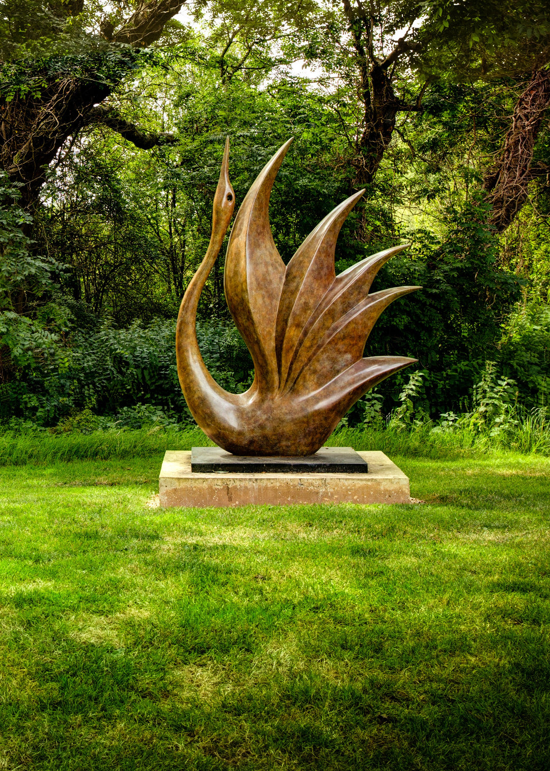 Simon Gudgeon bronze sculpture Bird of Happiness featuring an elegant crane-inspired contemporary bronze form with sweeping curved lines displayed within a landscaped garden setting.