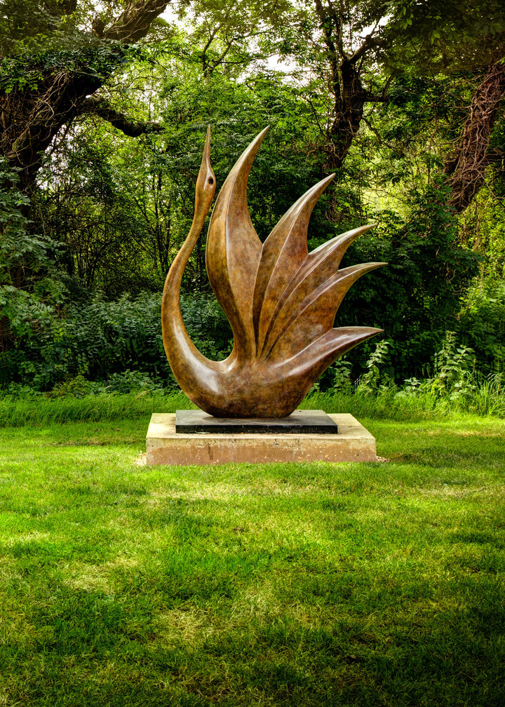 Simon Gudgeon bronze sculpture Bird of Happiness featuring an elegant crane-inspired contemporary bronze form with sweeping curved lines displayed within a landscaped garden setting.