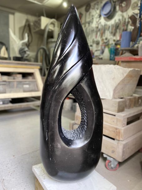 Black Swirl by Brendan Cullen, hand-carved from Nero Marquina and Spanish marble, a tall polished black sculpture with fluid swirling curves and an open centre revealing textured detailing.