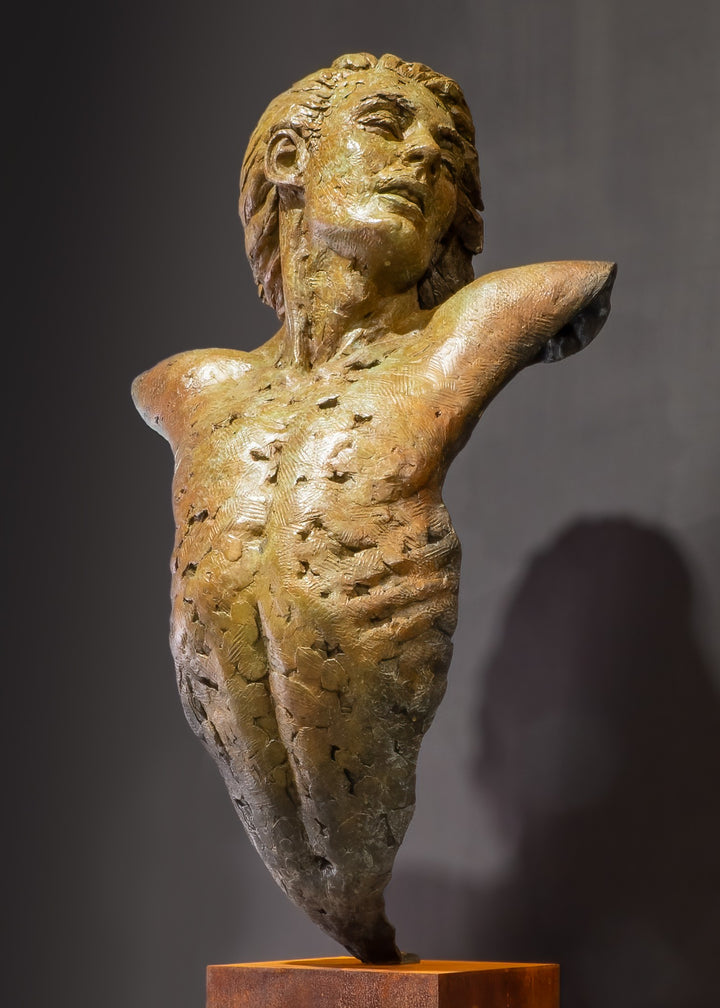 Nicola Godden Bliss Icarus bronze sculpture portraying a stylised human figure rising upward with arms extended and head turned, evoking a moment of release and quiet strength. The elongated form suggests lift and motion while remaining grounded through a solid Corten steel base. The textured bronze surface carries depth and variation, with light catching across its contours to enhance the sense of movement and presence.