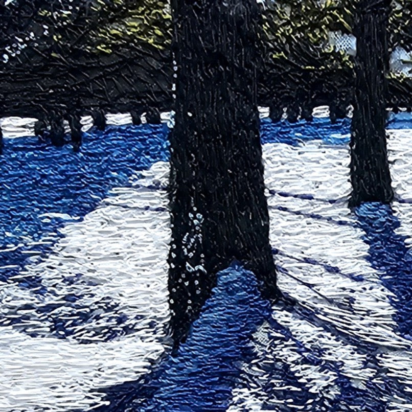 Textile artwork depicting blue winter shadows cast by trees across snow, created with freehand machine embroidery on painted silk.