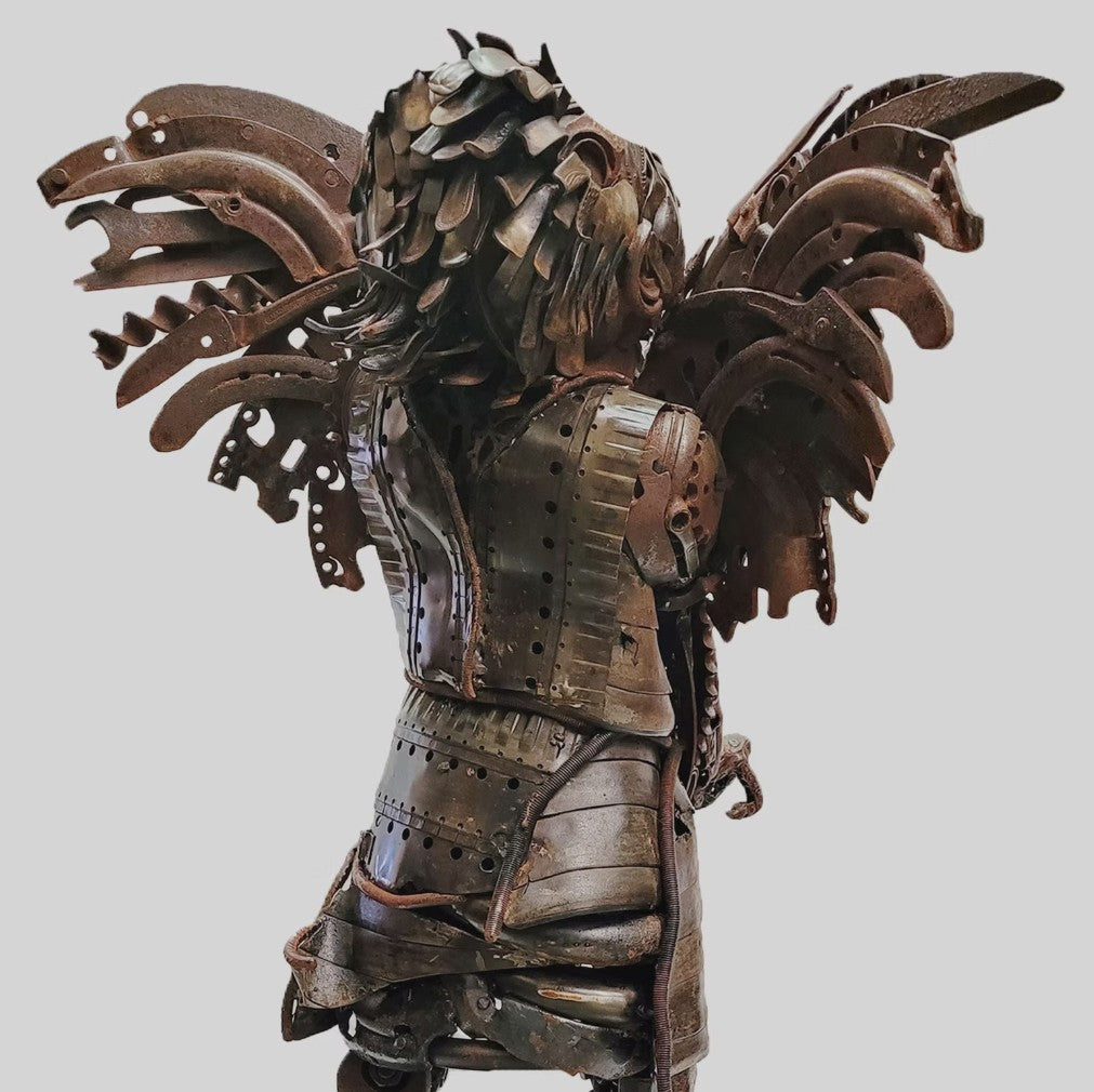 Fantasy warrior sculpture made from reclaimed metal with mechanical wings, gears, and armour detailing.