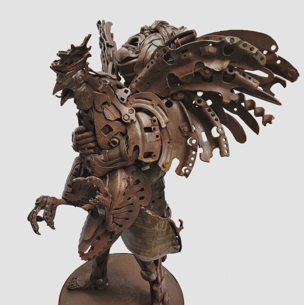 Fantasy warrior sculpture made from reclaimed metal with mechanical wings, gears, and armour detailing.