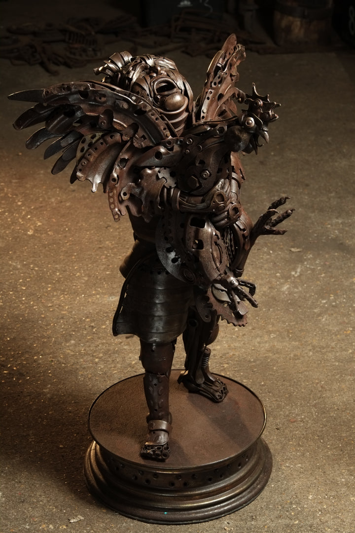 Fantasy warrior sculpture made from reclaimed metal with mechanical wings, gears, and armour detailing.