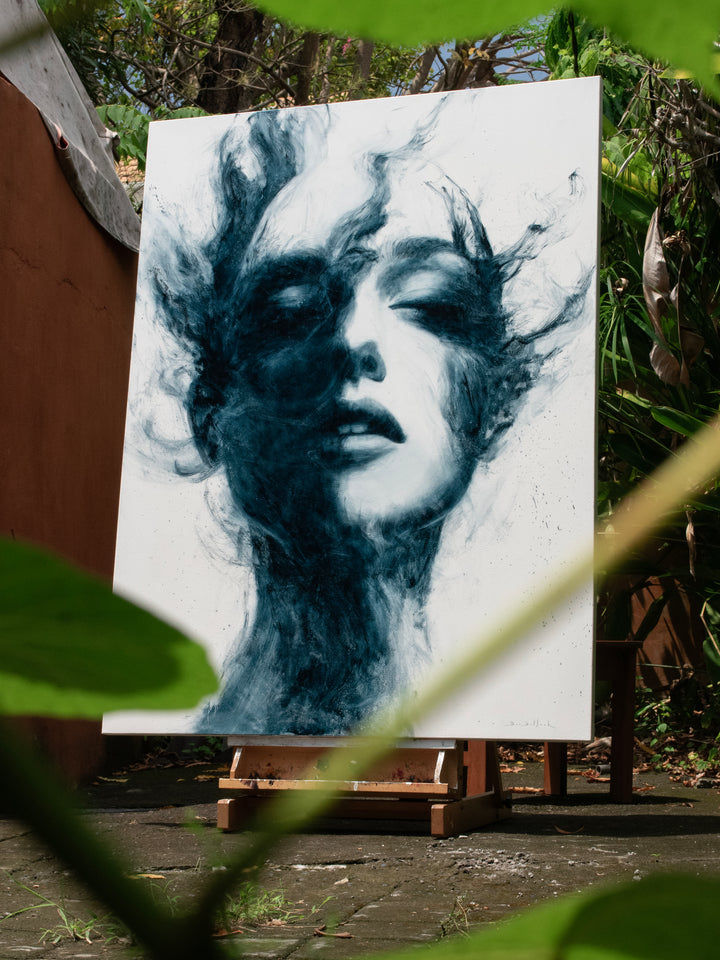 Large oil on canvas painting by Dan Bullock, titled Breathe. A monochrome portrait of a female face with eyes closed, emerging from swirling, smoky brushstrokes in deep teal and black against a pale background, balancing realism and abstraction.