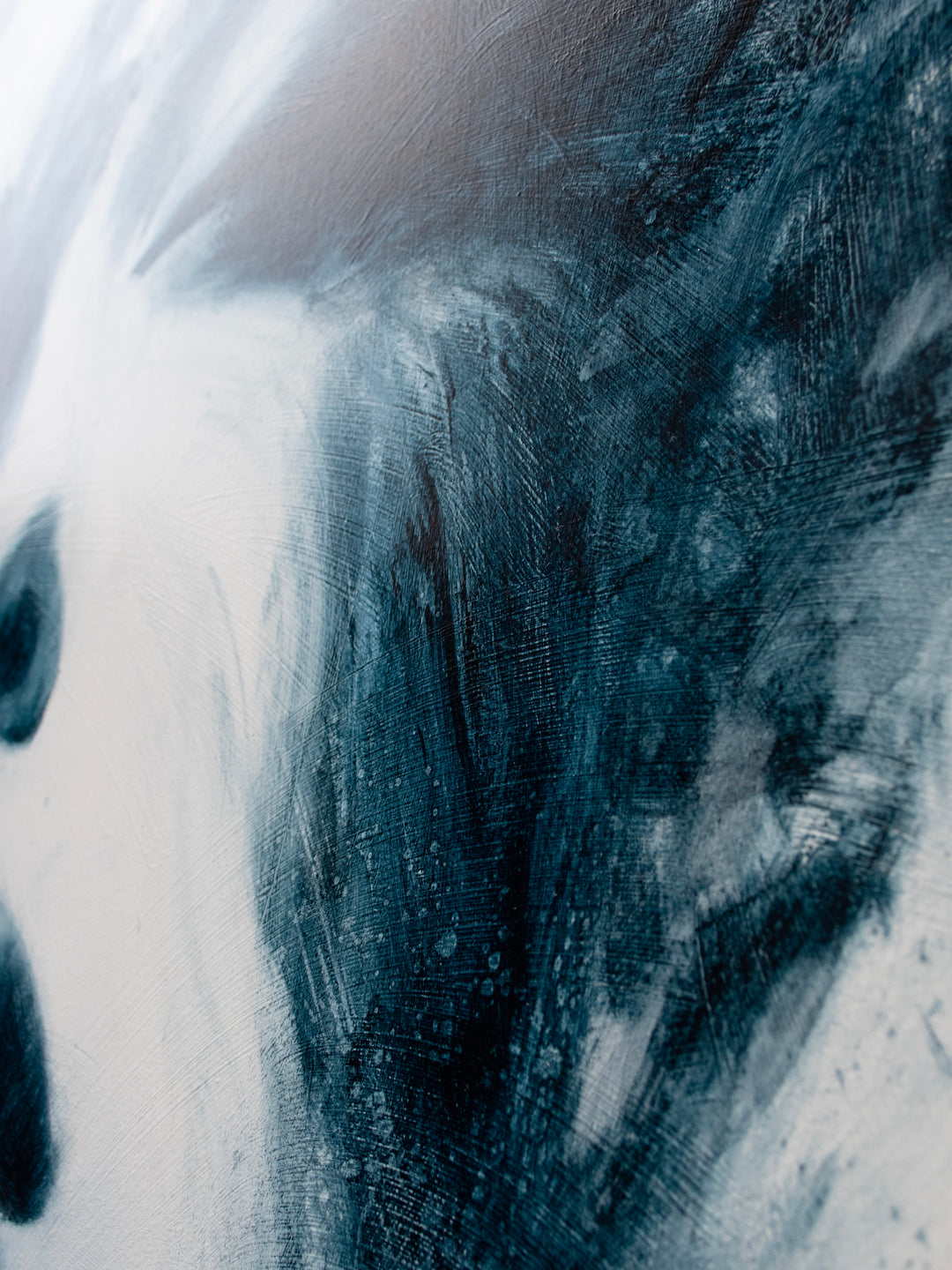 Large oil on canvas painting by Dan Bullock, titled Breathe. A monochrome portrait of a female face with eyes closed, emerging from swirling, smoky brushstrokes in deep teal and black against a pale background, balancing realism and abstraction.