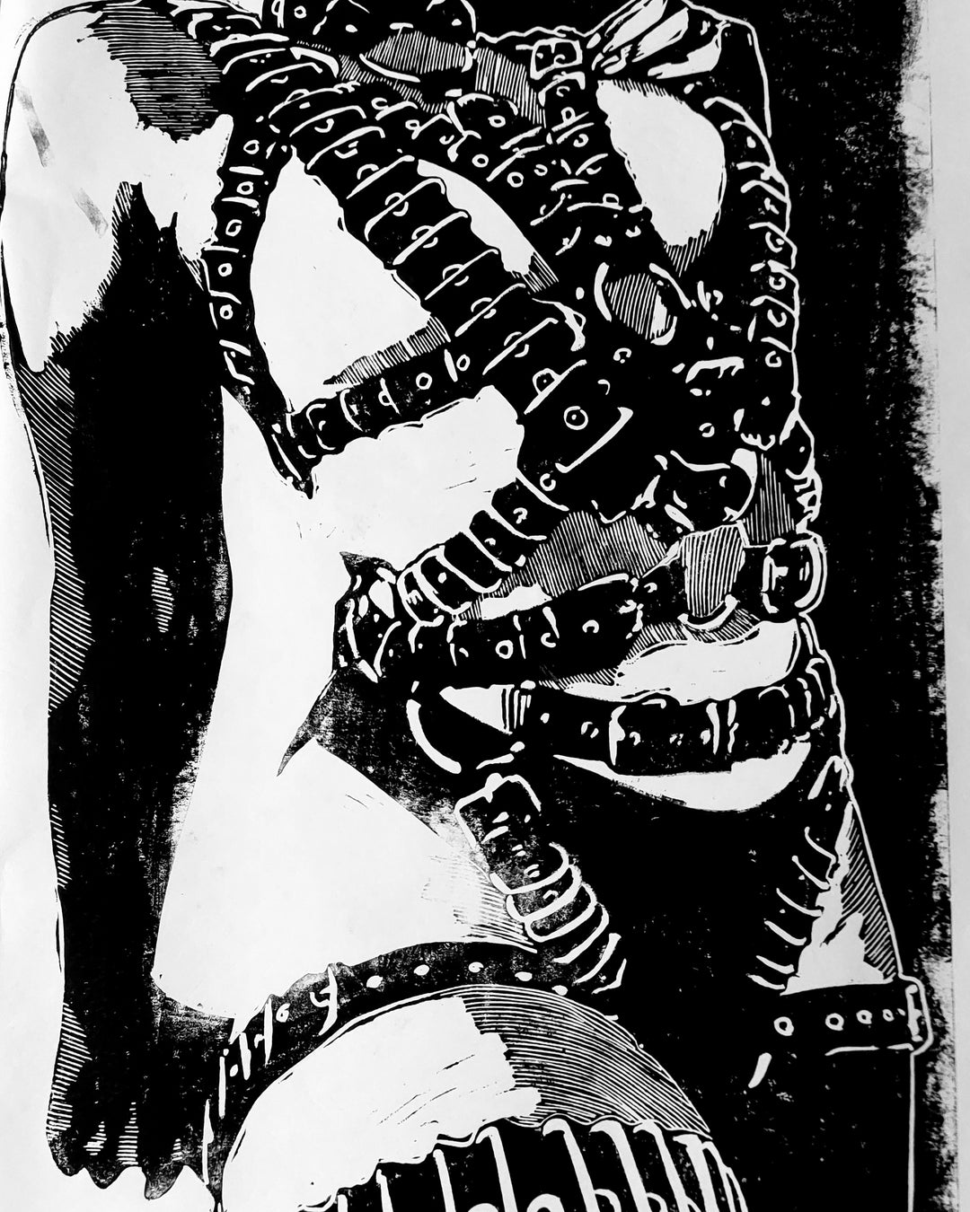 Monochrome linocut depicting a cropped torso in a full-body harness made entirely of layered leather belts with buckles. The detailed strapping wraps tightly across the figure, creating a powerful visual of control and constraint. Rendered in bold black and white with heavy contrast and textured edges, the composition evokes fetishwear, submission, and identity with raw graphic force.