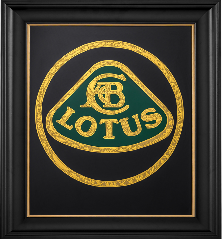 ‘CC Passion’ by Vince Edmunds, a handcrafted automotive artwork celebrating the British Lotus marque, featuring the classic Lotus emblem recreated in 24-carat gold leaf and glue-chipped glass. Intricately textured gold lettering and circular detailing surround the distinctive green Lotus badge against a deep black background, presented in a satin black frame with a fine gold sight line.