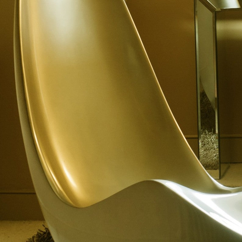 “Caillou Chaise – Metallic Wet Spray” by Ben Rousseau – a sculptural chaise inspired by 1960s grand tourers, hand-shaped in composite with a high-gloss metallic lacquered finish in white, lime, gold, or silver. A fusion of luxury design and form.
