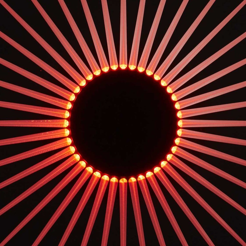 “Iris” by Ben Rousseau – a circular illuminated artwork crafted from engraved acrylic, combining nature’s geometry with digital precision. Red and amber light radiates from the centre, evoking the structure of a human iris in sculptural form.
