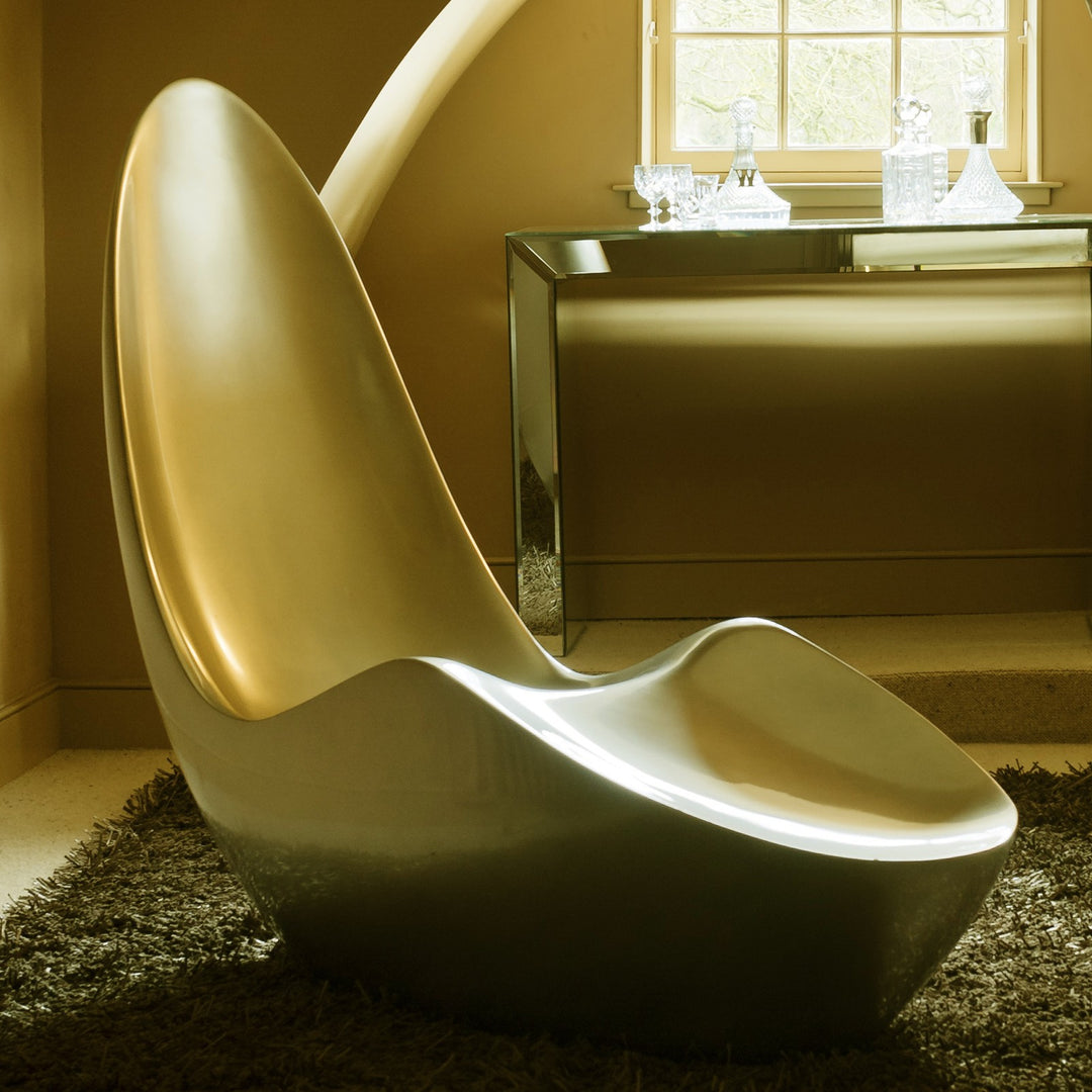 “Caillou Chaise – Metallic Wet Spray” by Ben Rousseau – a sculptural chaise inspired by 1960s grand tourers, hand-shaped in composite with a high-gloss metallic lacquered finish in white, lime, gold, or silver. A fusion of luxury design and form.

